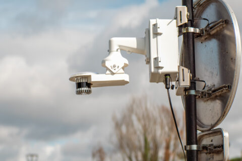 Inspemon monitoring machine mounted on an outdoor pole behind a traffic sign for real-time infrastructure data collection
