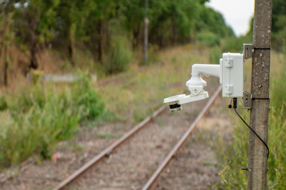 Inspemon monitoring machine positioned near railway tracks in a forested area for infrastructure monitoring.